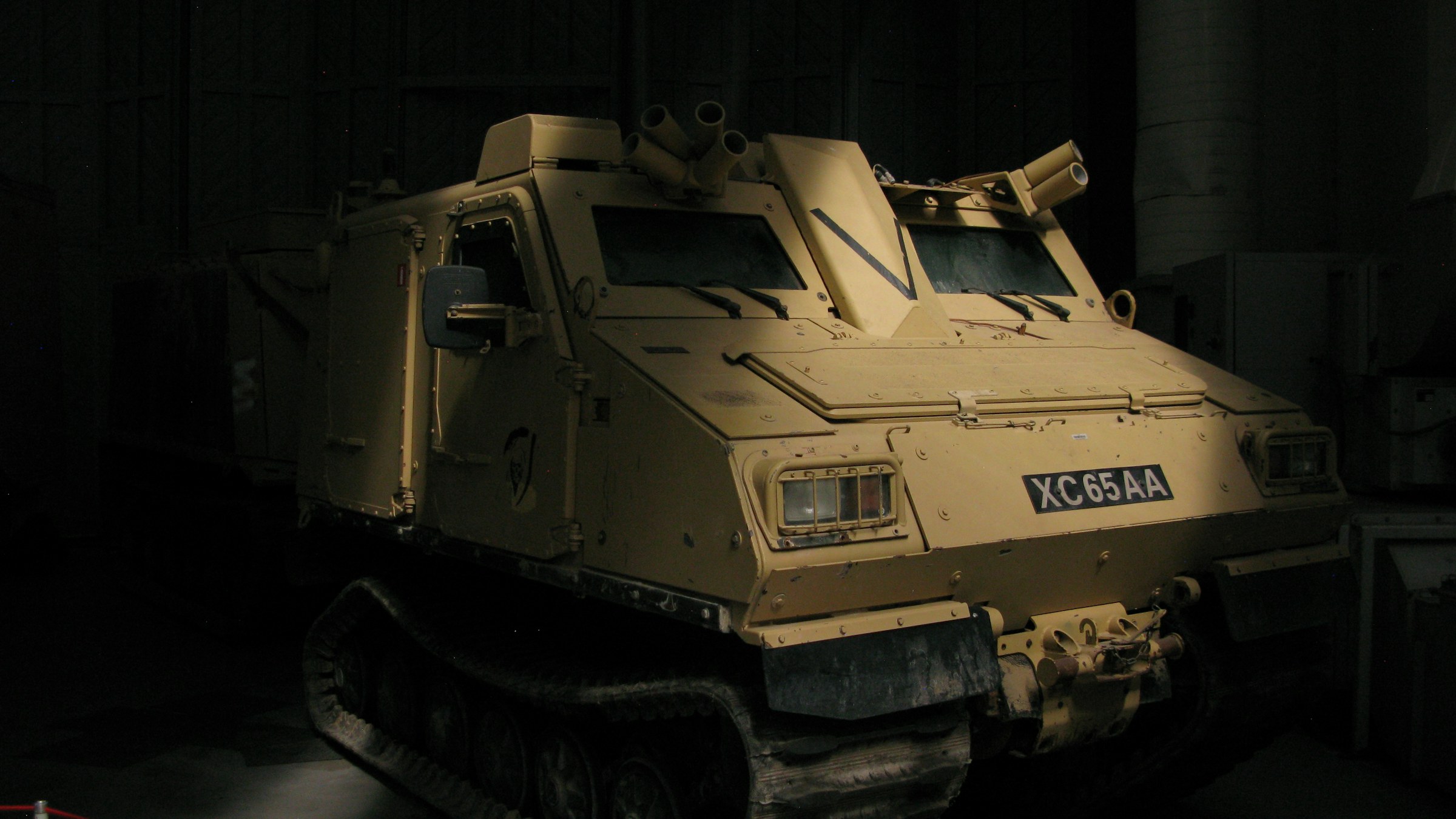 Military vehicle in dark depot bay